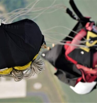 skoczek spadochronowy w locie widziany z góry ze spadochronikiem otwierającym czaszę